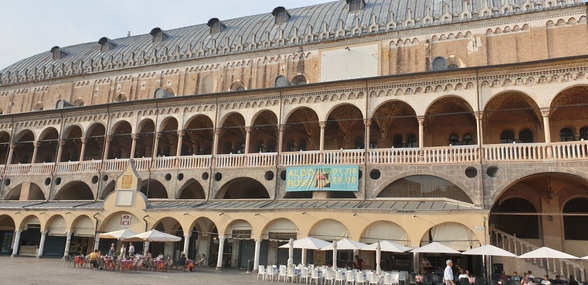 Верхний балкон Палаццо Раджоне расписан фресками; на нижем ярусе - рынок Соттосалоне