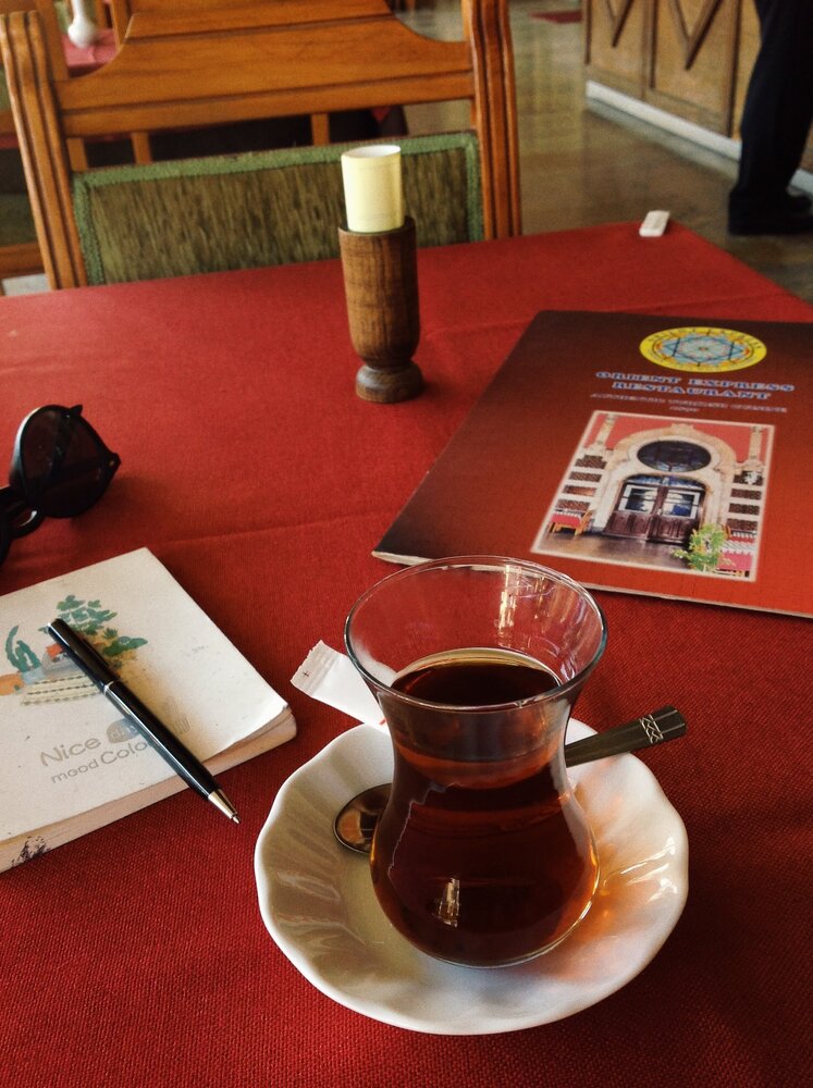 Order Turkish tea in a traditional tulip glass and observe the life of the train station