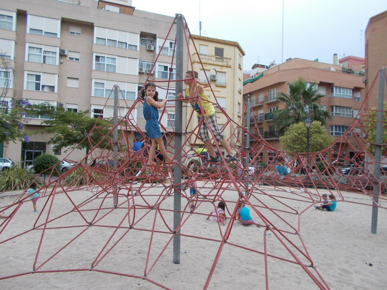 Детская площадка с песком и сетками  в обычном дворе